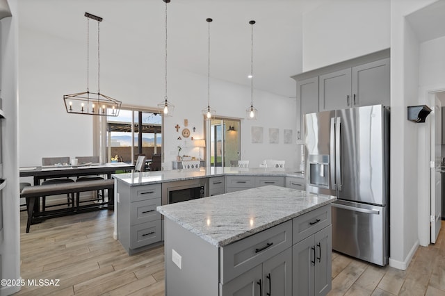 3337 E Wet Sand Pl, Vail, AZ 85641 - kitchen featuring appliances with stainless steel finishes, gray cabinetry, a peninsula, a kitchen island, and a towering ceiling