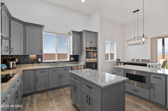3337 E Wet Sand Pl, Vail, AZ 85641 - kitchen featuring gray cabinetry, appliances with stainless steel finishes, a sink, light wood finished floors, and a kitchen island