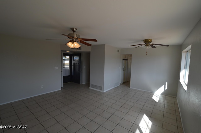 spare room with light tile patterned floors, plenty of natural light, and a ceiling fan