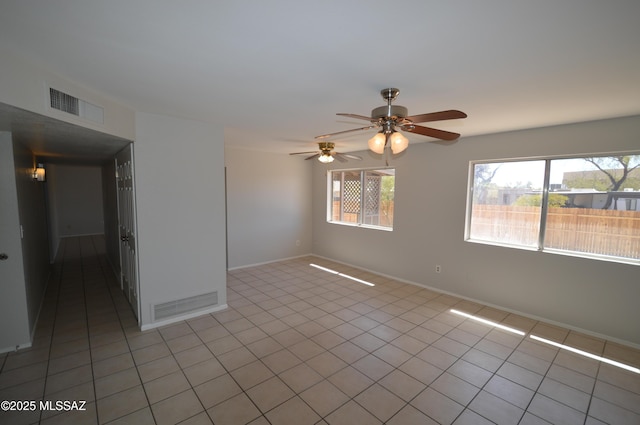unfurnished room with light tile patterned flooring, baseboards, ceiling fan, and visible vents