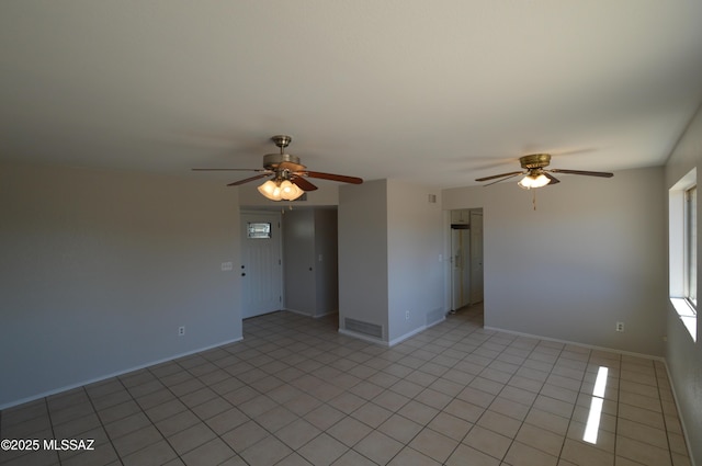 unfurnished room with a ceiling fan, light tile patterned floors, baseboards, and visible vents