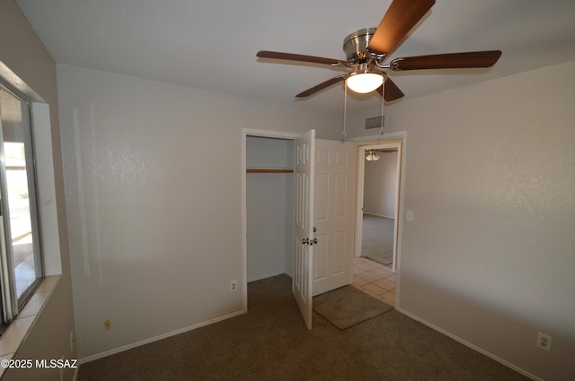 unfurnished bedroom with a ceiling fan, visible vents, carpet floors, and baseboards