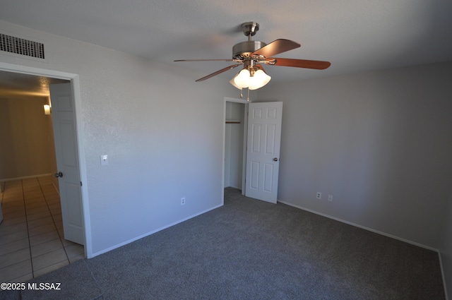 unfurnished bedroom featuring tile patterned floors, visible vents, carpet floors, and baseboards