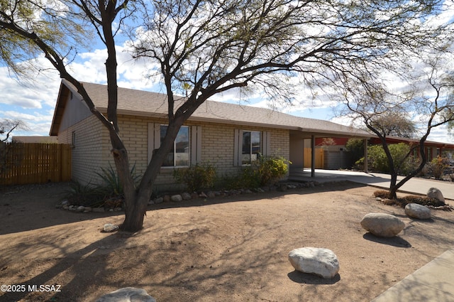 single story home with fence and brick siding