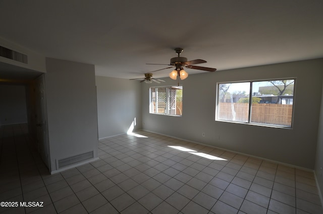 tiled empty room with visible vents and baseboards