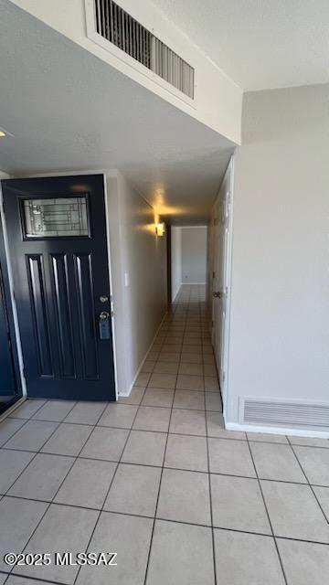 corridor with light tile patterned floors and visible vents