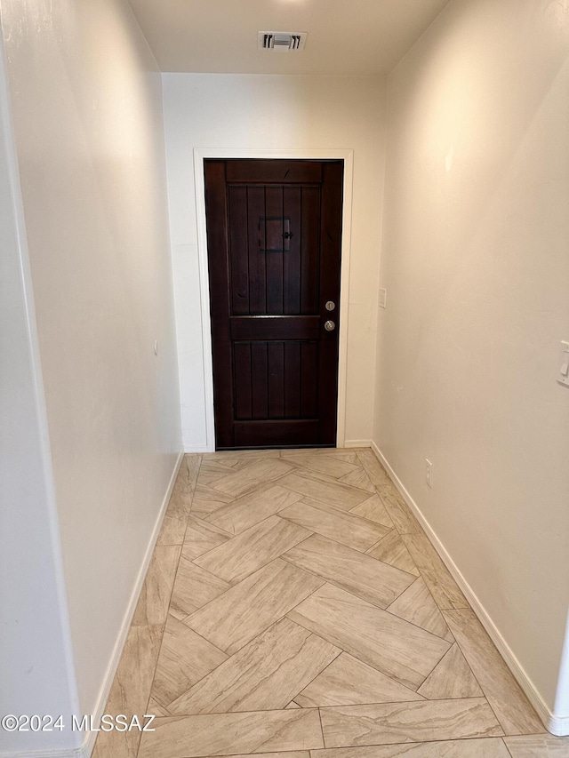 doorway with visible vents and baseboards