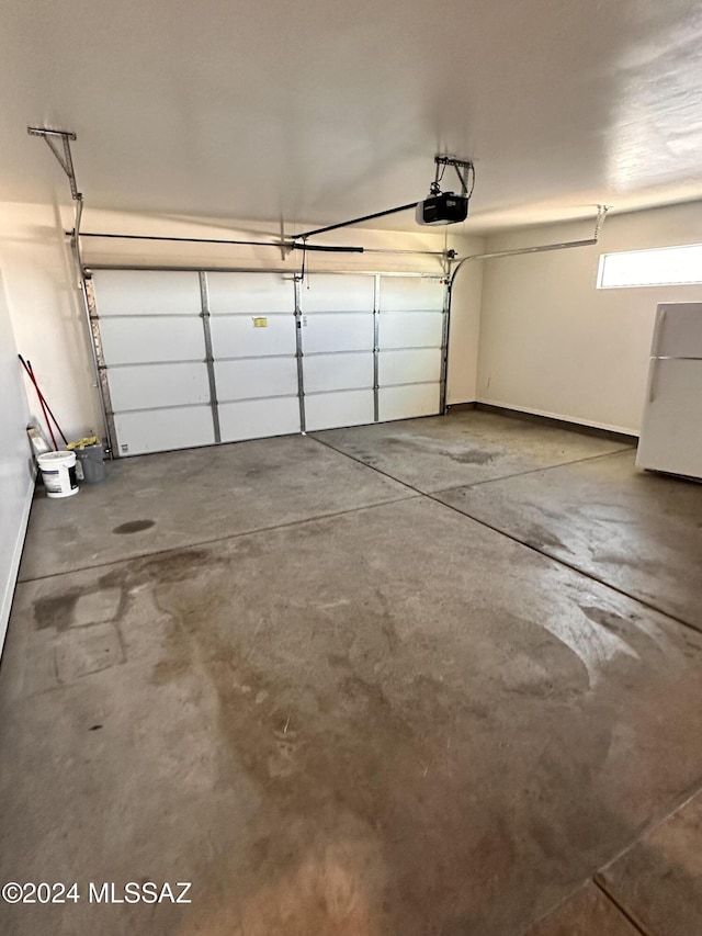 garage featuring a garage door opener and freestanding refrigerator