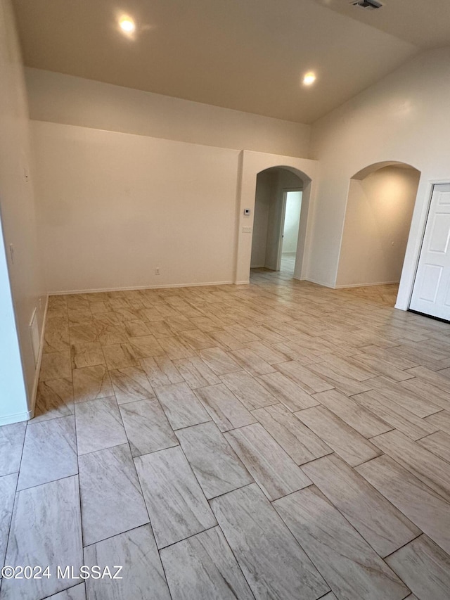 spare room featuring arched walkways