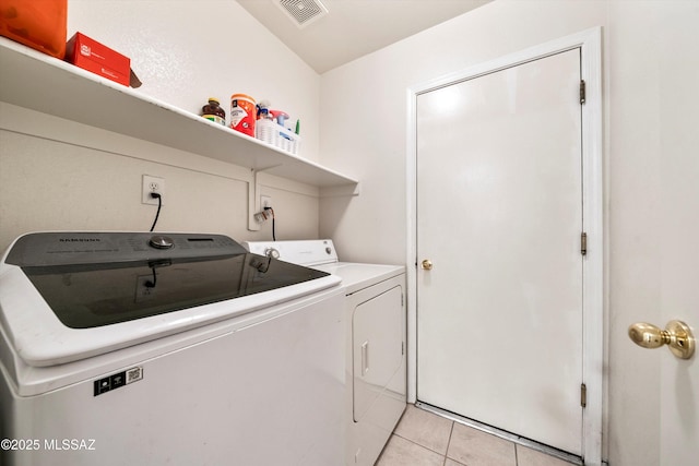 laundry room featuring washer and dryer, laundry area, light tile patterned floors, and visible vents