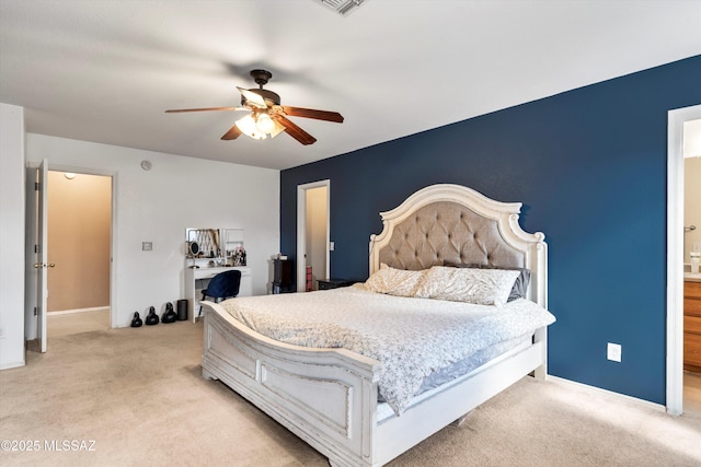 bedroom featuring light carpet, a ceiling fan, ensuite bath, and baseboards