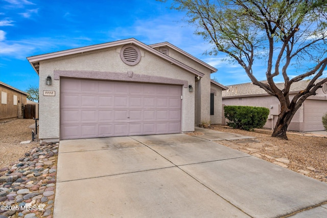 single story home featuring stucco siding, driveway, and a garage