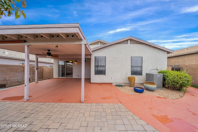 rear view of house with a patio area, central air condition unit, fence, and stucco siding