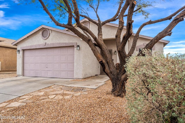 view of front of house featuring stucco siding, an attached garage, and concrete driveway