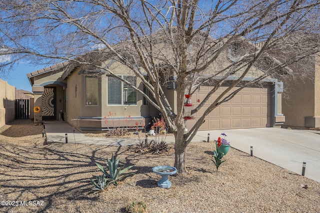 view of front of property featuring stucco siding, an attached garage, concrete driveway, and fence