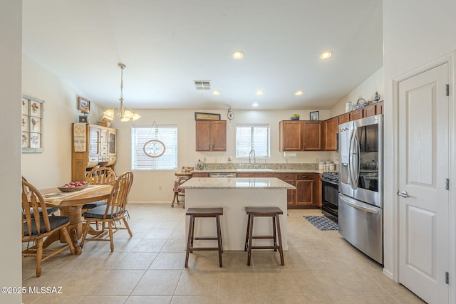 kitchen featuring visible vents, stainless steel refrigerator with ice dispenser, a sink, gas stove, and an inviting chandelier