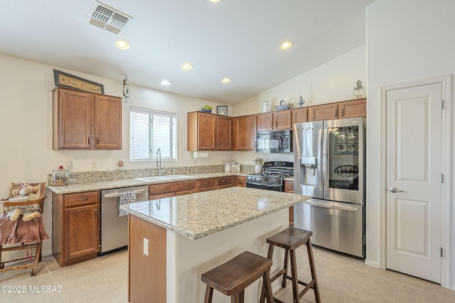 kitchen featuring visible vents, a sink, stainless steel appliances, light tile patterned flooring, and brown cabinetry