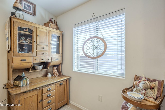 interior space with light tile patterned flooring, a healthy amount of sunlight, and baseboards