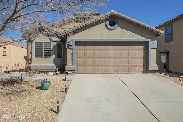 view of front of home featuring a tiled roof, stucco siding, driveway, and a garage