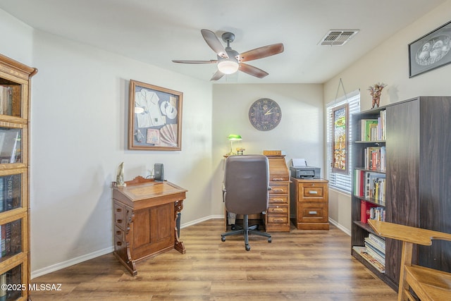 office area with ceiling fan, visible vents, baseboards, and wood finished floors