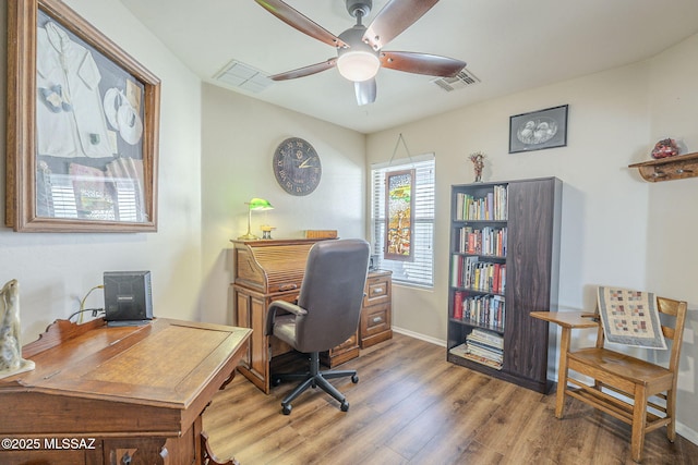 office featuring visible vents, baseboards, ceiling fan, and wood finished floors