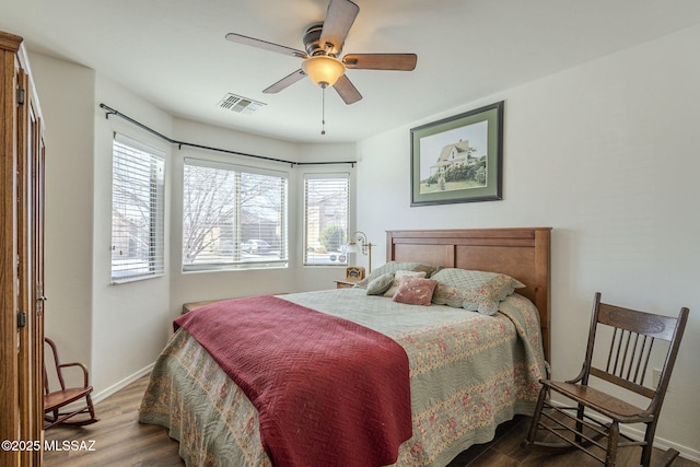 bedroom featuring ceiling fan, wood finished floors, visible vents, and baseboards