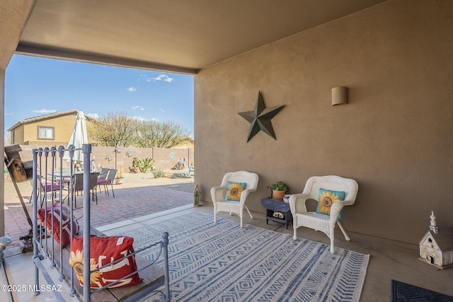 view of patio featuring outdoor dining space, outdoor lounge area, and fence