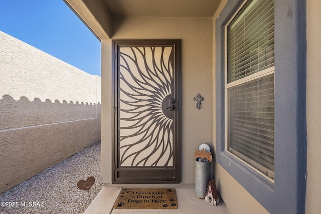 doorway to property featuring stucco siding