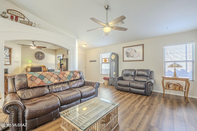 living room featuring visible vents, wood finished floors, arched walkways, ceiling fan, and vaulted ceiling