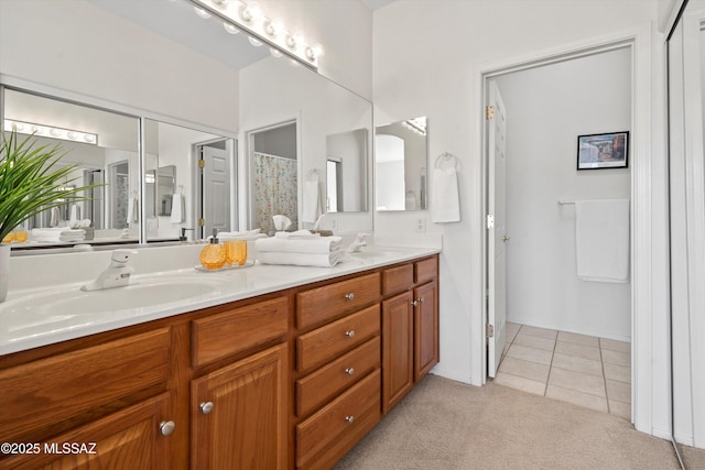 bathroom with tile patterned floors, a shower with curtain, double vanity, and a sink