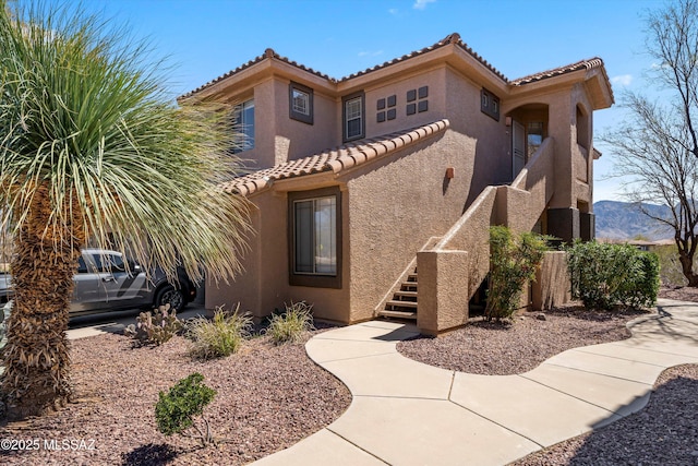 mediterranean / spanish-style home with stucco siding and a tiled roof