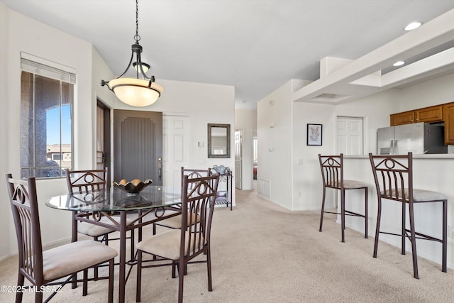 dining room featuring baseboards and light colored carpet