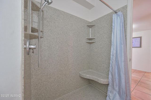 bathroom with tile patterned floors and tiled shower