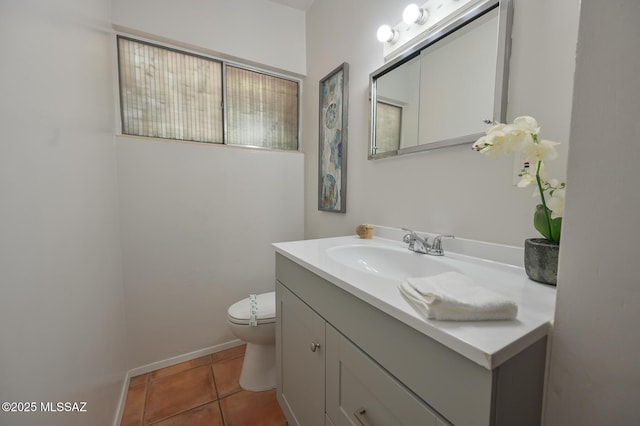 half bathroom featuring baseboards, toilet, vanity, and tile patterned flooring