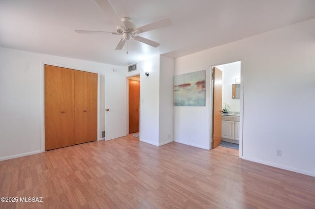 unfurnished bedroom with visible vents, baseboards, light wood-type flooring, ensuite bathroom, and a closet