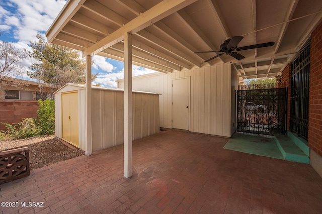 view of patio / terrace featuring an outbuilding, a ceiling fan, fence, and a shed