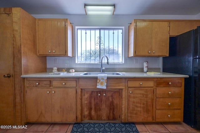 kitchen featuring a sink, decorative backsplash, and light tile patterned floors