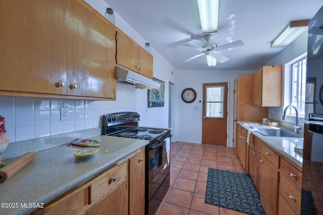 kitchen featuring light tile patterned floors, electric range, a sink, under cabinet range hood, and backsplash