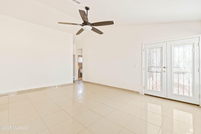 empty room with french doors, lofted ceiling, light tile patterned flooring, and a ceiling fan