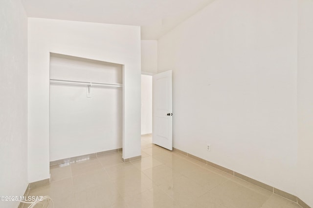 unfurnished bedroom featuring light tile patterned flooring and a closet