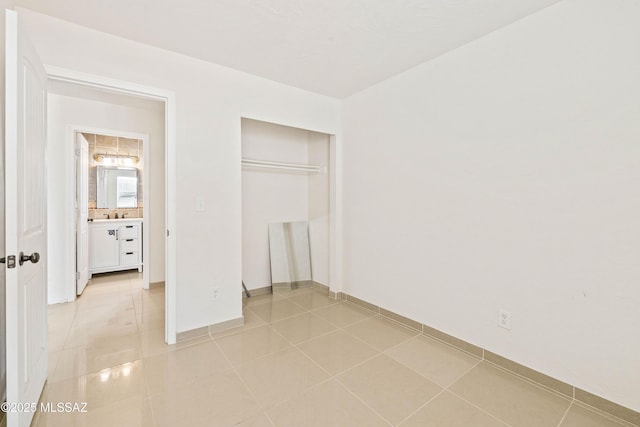 unfurnished bedroom with light tile patterned floors and a closet