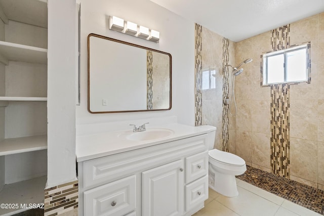 full bath featuring vanity, toilet, tile patterned flooring, and tiled shower