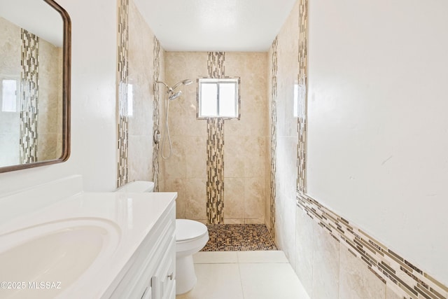 full bathroom with tile patterned floors, toilet, vanity, and a tile shower