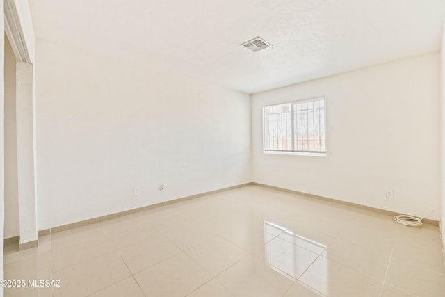 unfurnished room featuring light tile patterned floors, baseboards, and visible vents