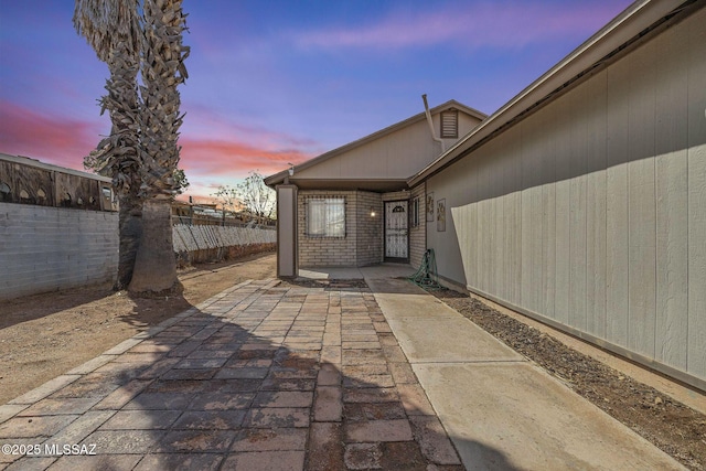 patio terrace at dusk featuring fence