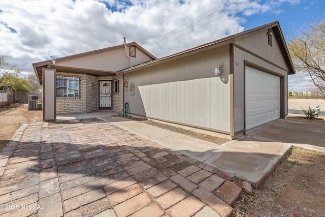 ranch-style home with concrete driveway and central AC