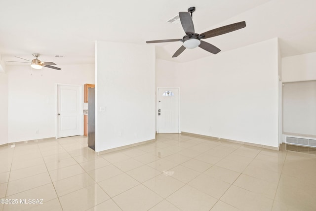 unfurnished room featuring light tile patterned floors, visible vents, baseboards, and a ceiling fan