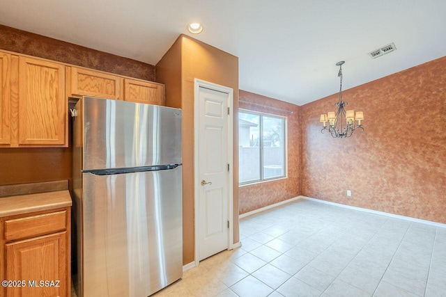 kitchen with visible vents, freestanding refrigerator, wallpapered walls, baseboards, and light countertops