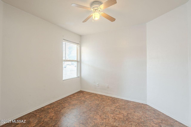 empty room featuring baseboards and ceiling fan