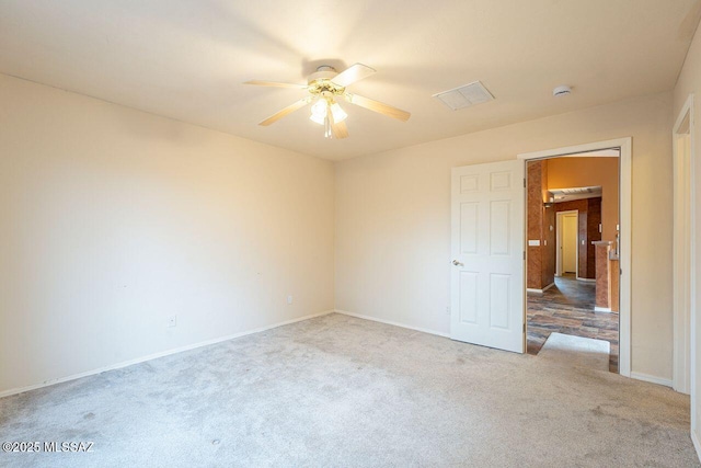 empty room featuring carpet flooring, baseboards, and ceiling fan